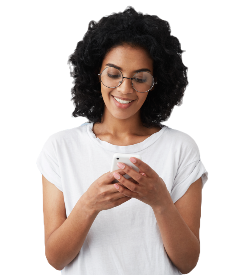 A woman with curly hair and glasses smiles while using a smartphone.